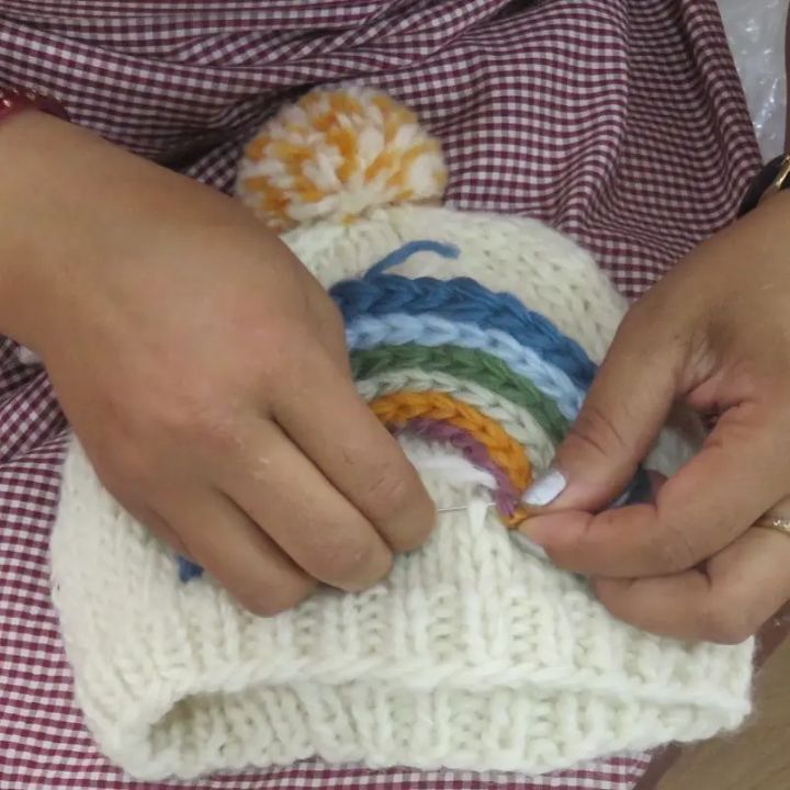 Child's knitted woollen hat - rainbow hat handmade and Fair Trade ages 1 - 2 years - artisan making the hat