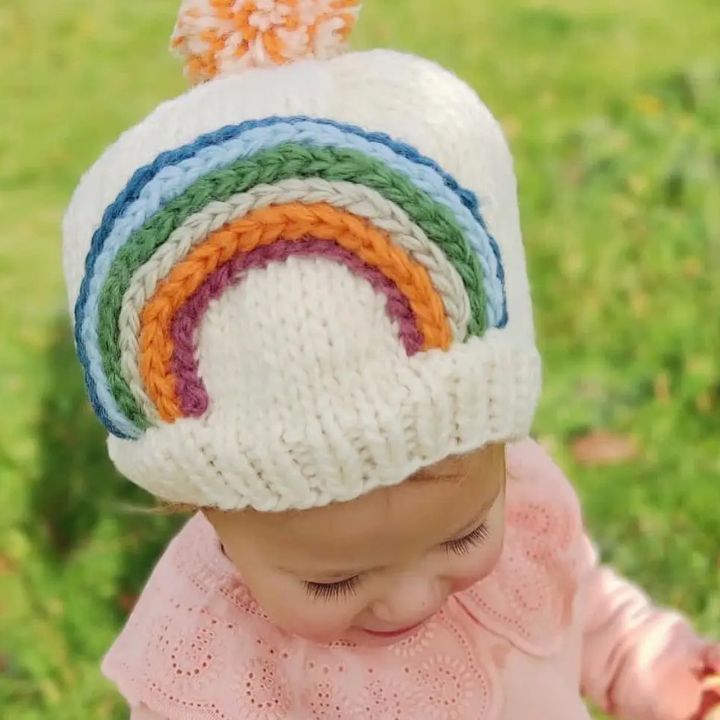 Child wearing knitted woollen hat - rainbow hat handmade and Fair Trade ages 1 - 2 years